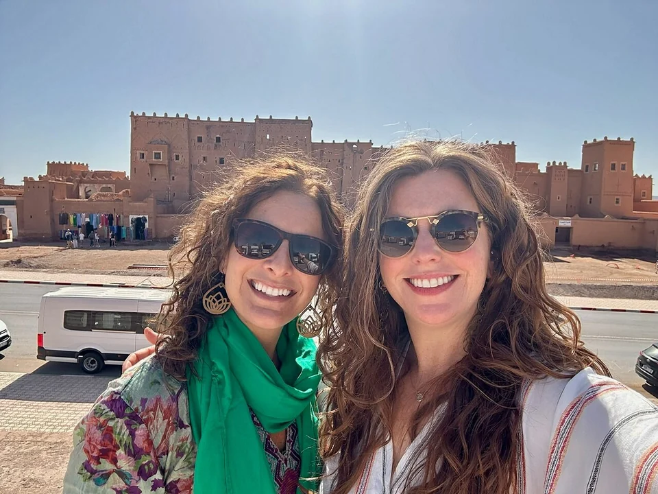 Travelers beside a traditional kasbah during a three-day Merzouga to Marrakech tour